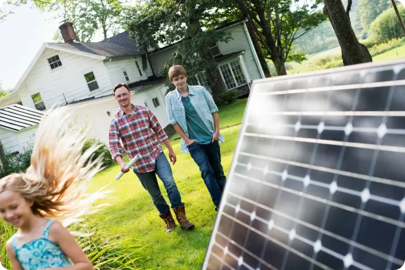 Štastná rodina se zelenou elektřinou a solárním panelem