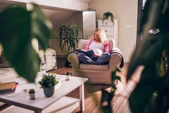 Žena sedí na pohodlném křesle doma